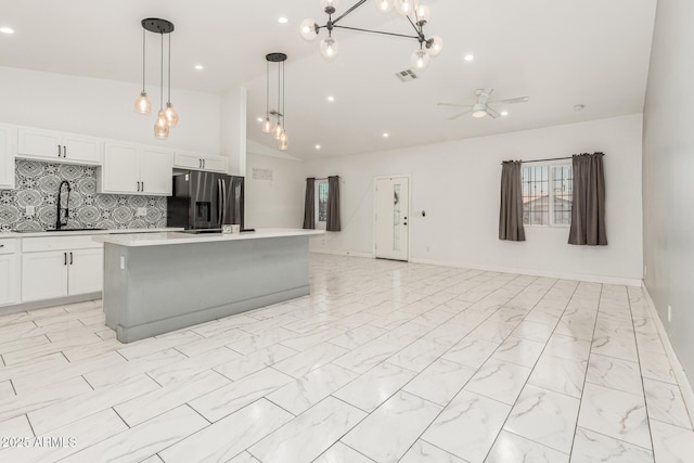 3614 W Granada Rd, Phoenix, AZ 85009 - kitchen featuring stainless steel refrigerator with ice dispenser, light countertops, open floor plan, a kitchen island, and white cabinetry