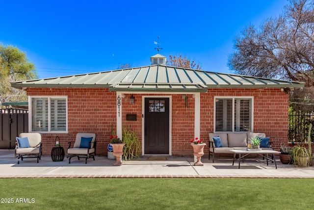 back of property with an outdoor living space, a patio area, and a lawn