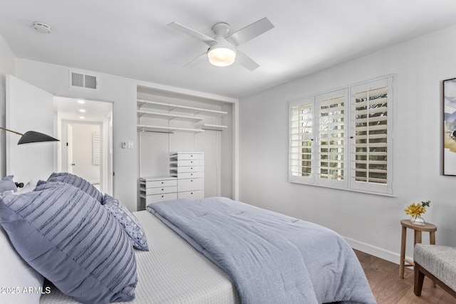 bedroom featuring wood-type flooring, ceiling fan, and a closet