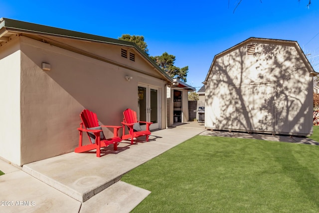 back of house featuring a yard, a patio area, and a storage unit