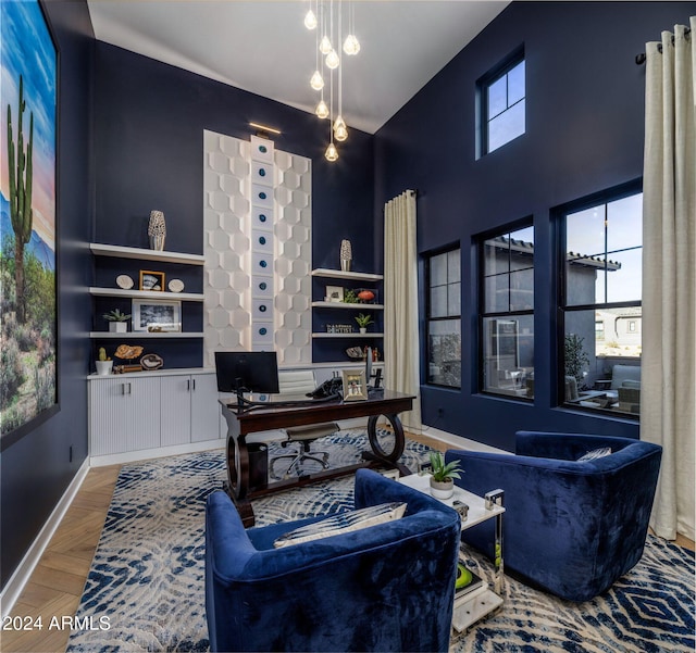 home office featuring parquet floors, a towering ceiling, and a wealth of natural light