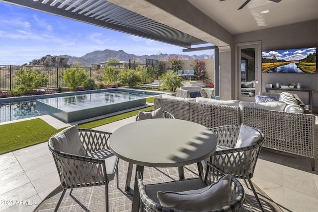 view of patio with a fenced in pool, an outdoor hangout area, and ceiling fan