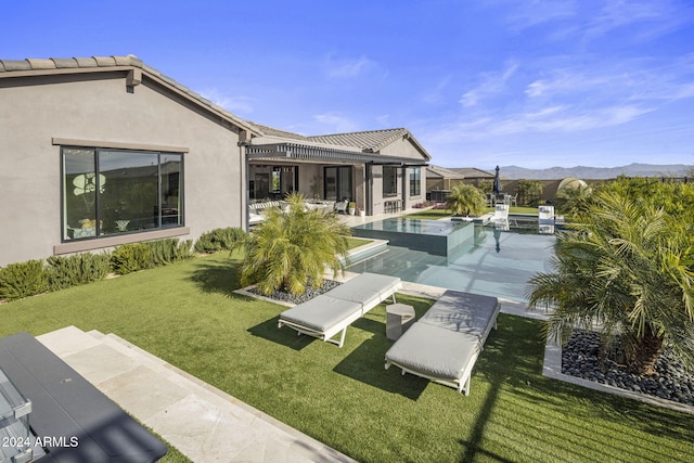 exterior space featuring a swimming pool with hot tub, a mountain view, a yard, and a patio area