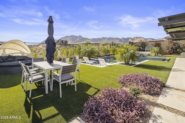 view of yard featuring a fenced in pool, a mountain view, and a patio