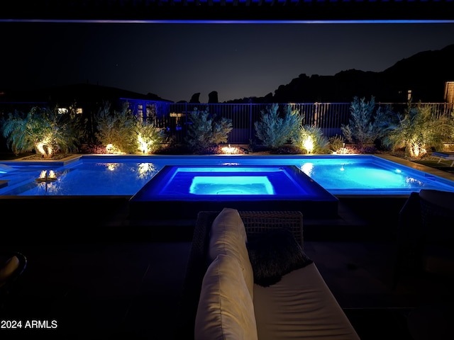 pool at twilight with an in ground hot tub