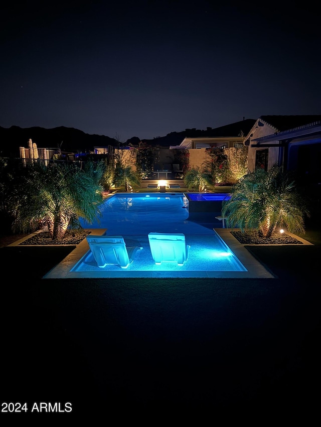 view of pool at twilight