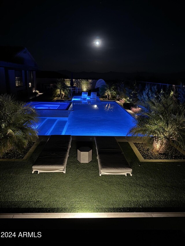 pool at night with a lawn