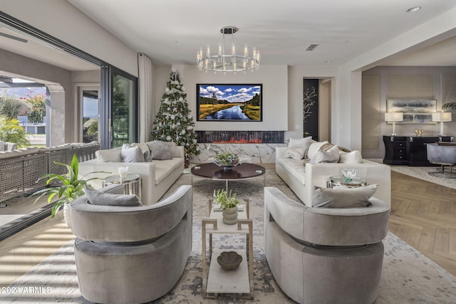 living room with parquet floors and an inviting chandelier