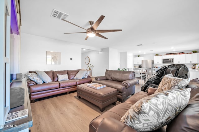 living room with ceiling fan and light hardwood / wood-style floors