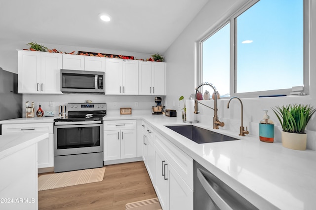 kitchen featuring white cabinets, light hardwood / wood-style floors, sink, and appliances with stainless steel finishes