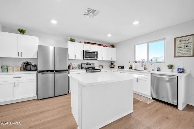 kitchen featuring white cabinets, a kitchen island, light hardwood / wood-style floors, and appliances with stainless steel finishes