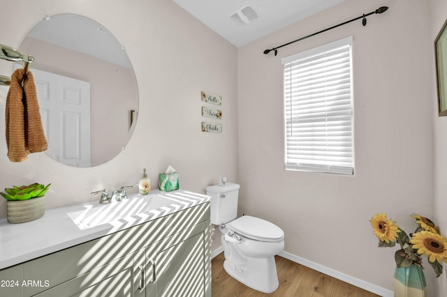 bathroom with hardwood / wood-style floors, vanity, and toilet