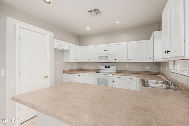 kitchen with white cabinets, light tile patterned floors, kitchen peninsula, sink, and white appliances