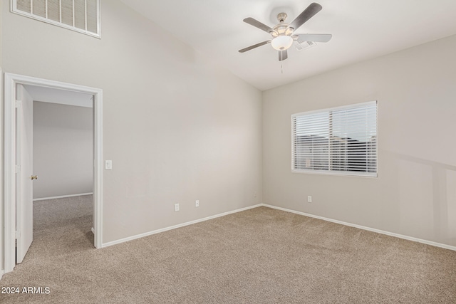 carpeted spare room featuring ceiling fan and vaulted ceiling