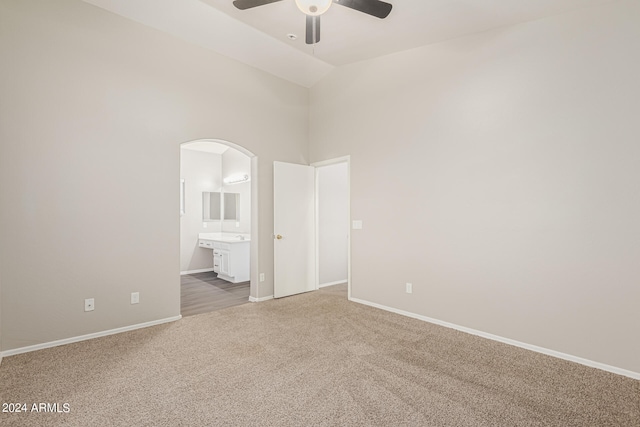 empty room with high vaulted ceiling, carpet, and ceiling fan