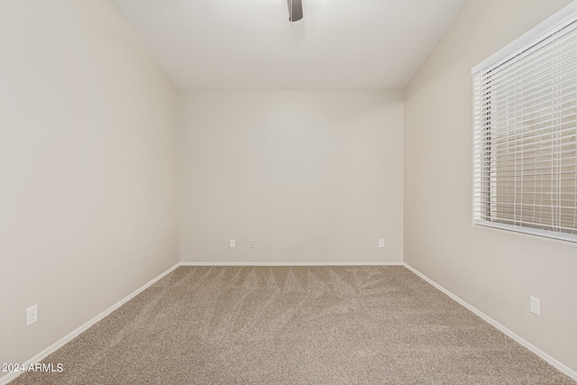 carpeted spare room featuring ceiling fan