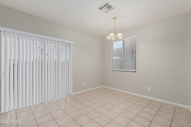 unfurnished room featuring light tile patterned floors and an inviting chandelier