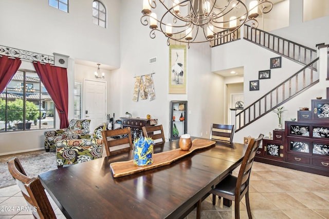 tiled dining area with a chandelier and a high ceiling