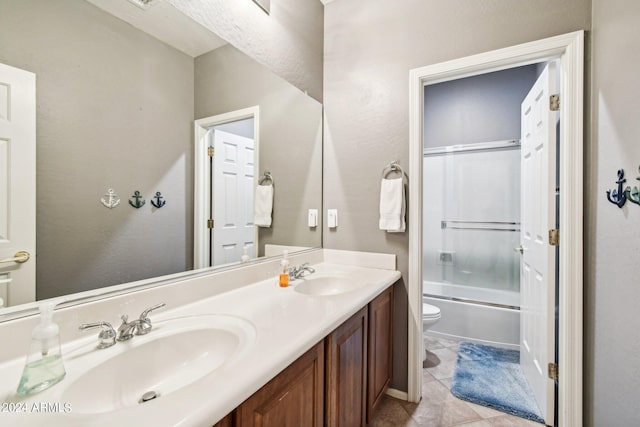 full bathroom featuring toilet, vanity, combined bath / shower with glass door, and tile patterned floors