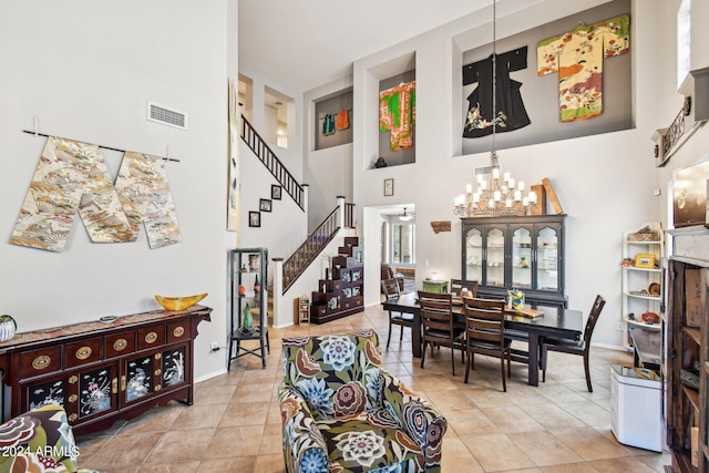 living room with an inviting chandelier, light tile patterned floors, and a towering ceiling