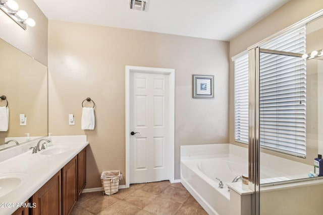 bathroom featuring vanity, a tub to relax in, and tile patterned flooring