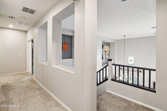 hall featuring a notable chandelier and carpet