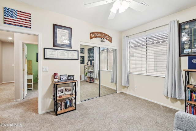 interior space with a closet, light carpet, and ceiling fan