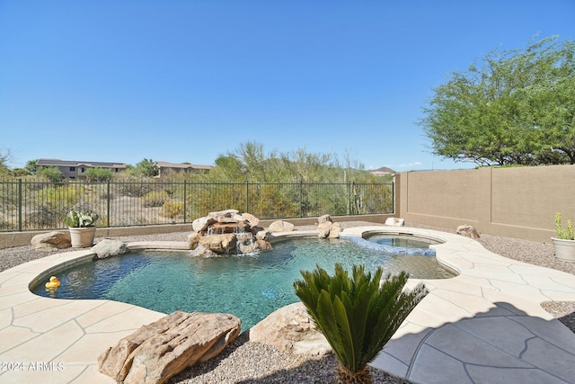 view of pool with a patio area, pool water feature, and an in ground hot tub