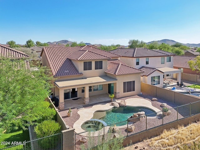 rear view of house featuring a mountain view, a patio, and a fenced in pool