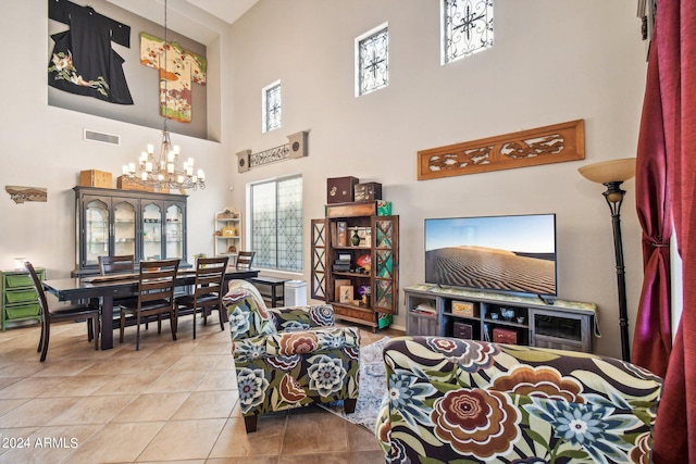 tiled living room featuring a chandelier and a high ceiling