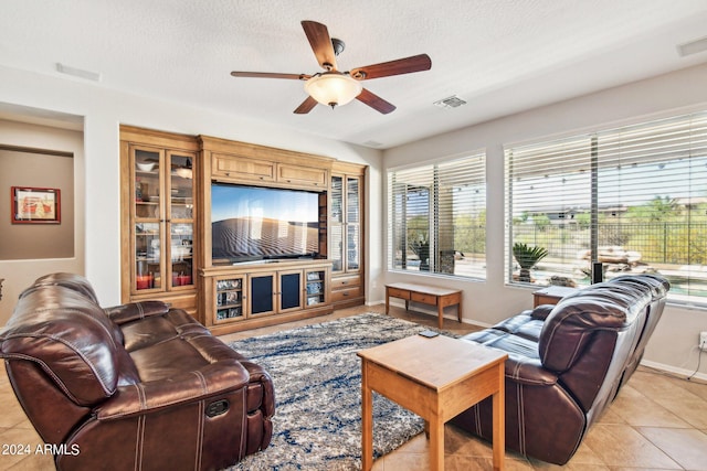 living room featuring a textured ceiling, ceiling fan, and light tile patterned flooring