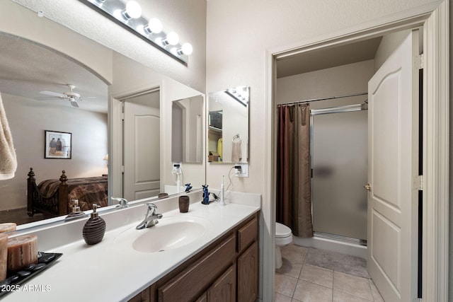 bathroom featuring toilet, vanity, a shower with shower curtain, ceiling fan, and tile patterned flooring