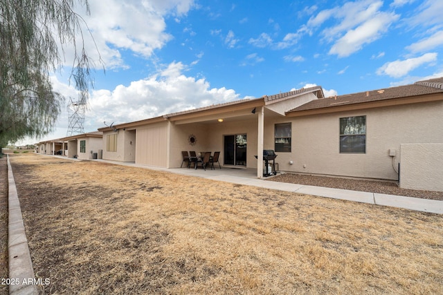 rear view of property with a patio and a lawn