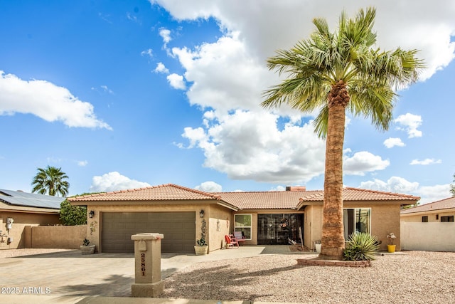 view of front of property featuring fence, an attached garage, stucco siding, concrete driveway, and a tile roof