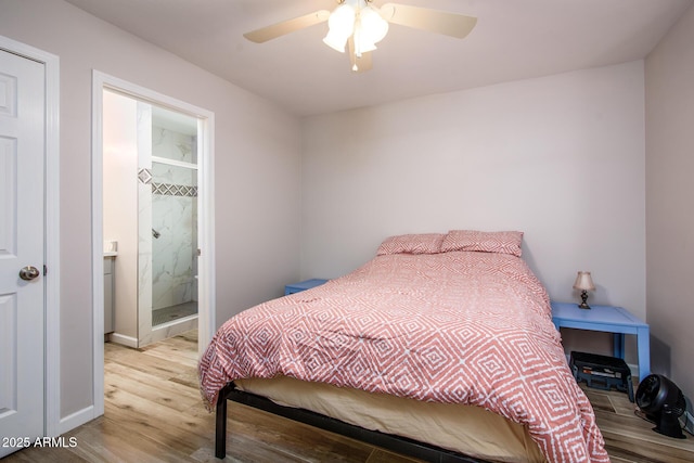 bedroom with ceiling fan, connected bathroom, baseboards, and wood finished floors