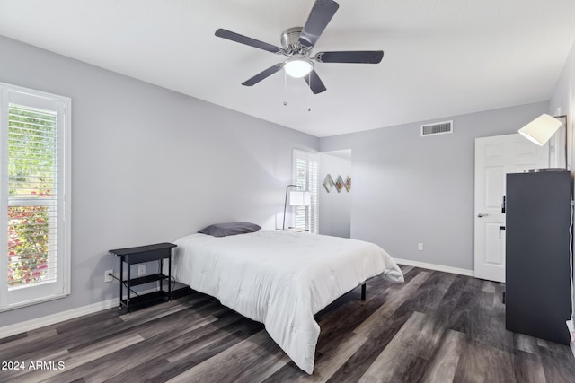 bedroom featuring dark hardwood / wood-style floors, multiple windows, and ceiling fan