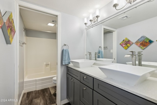 full bathroom featuring vanity, hardwood / wood-style flooring, toilet, and tub / shower combination