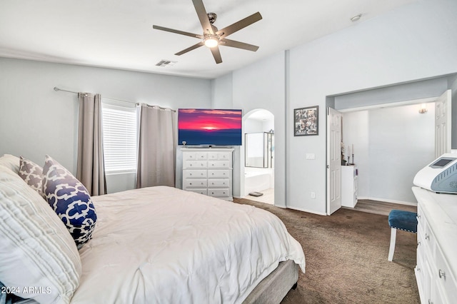 bedroom with connected bathroom, lofted ceiling, dark carpet, and ceiling fan