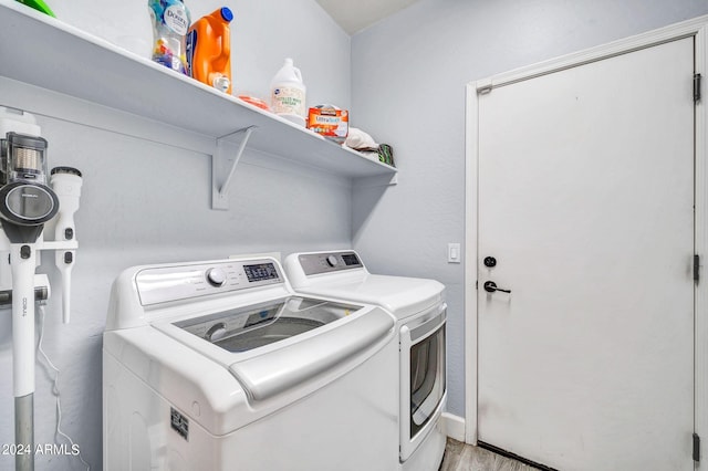 laundry room featuring light hardwood / wood-style flooring and separate washer and dryer