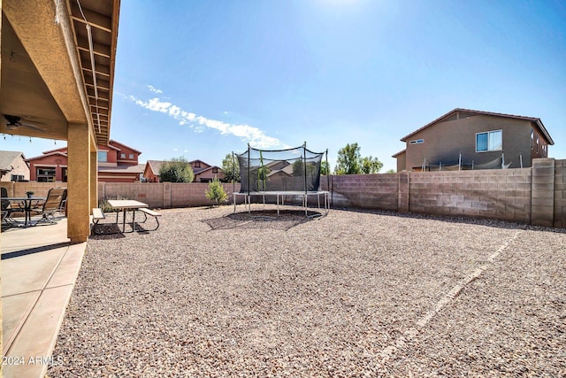 view of yard with a trampoline and a patio area