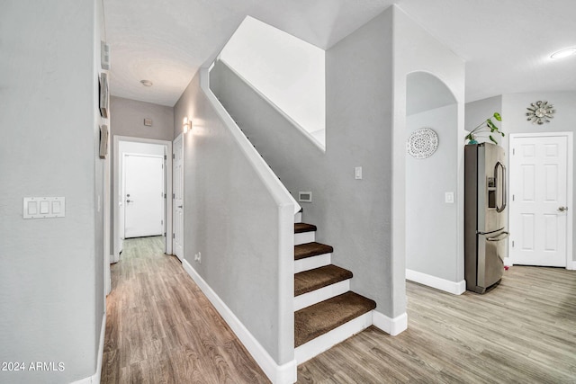 staircase with hardwood / wood-style floors