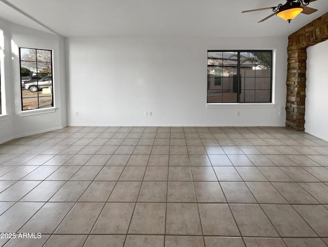 spare room with ceiling fan and light tile patterned floors