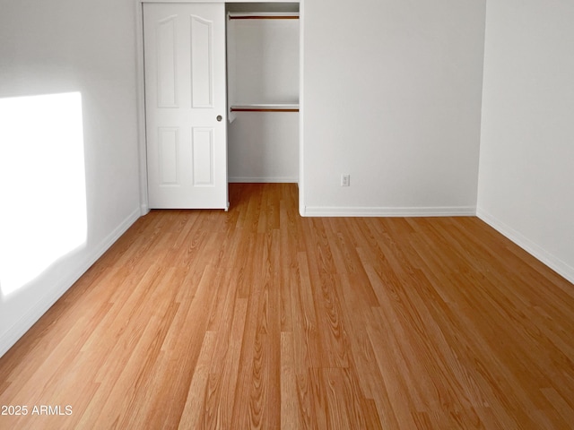 unfurnished bedroom with a closet and light hardwood / wood-style flooring