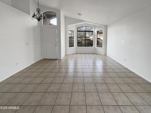 tiled foyer entrance with a chandelier and vaulted ceiling