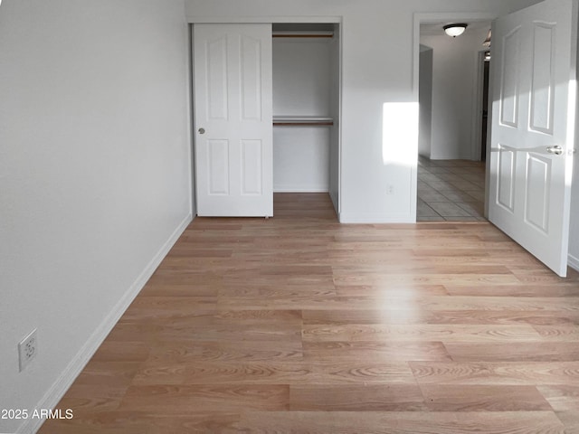 unfurnished bedroom featuring light wood-type flooring and a closet