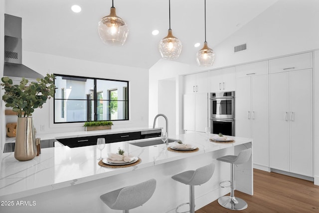 kitchen featuring vaulted ceiling, light stone countertops, visible vents, double oven, and a sink