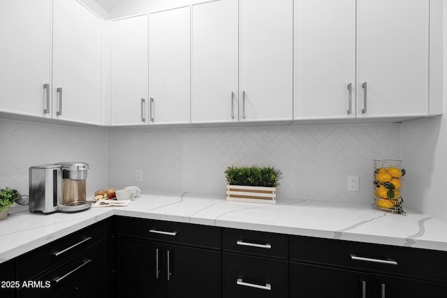 kitchen with backsplash, white cabinets, and dark cabinets