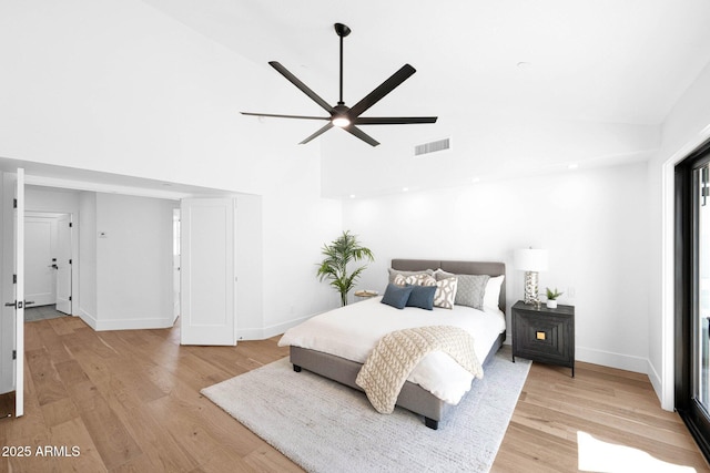 bedroom featuring visible vents, light wood-style flooring, high vaulted ceiling, and baseboards