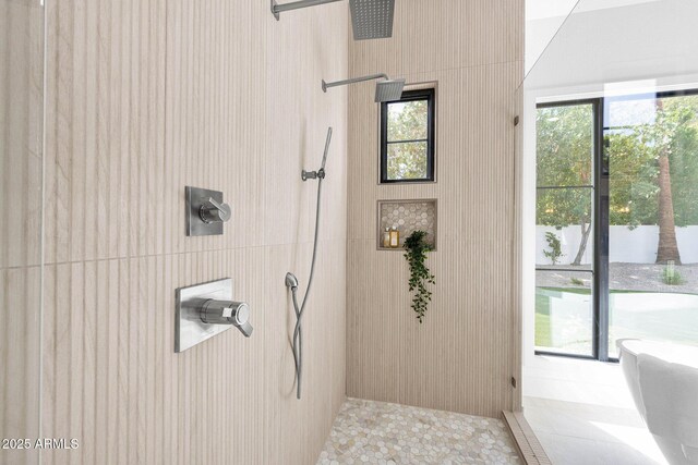 full bathroom featuring tiled shower and plenty of natural light