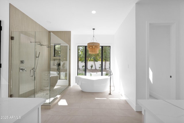 bathroom featuring recessed lighting, a freestanding tub, baseboards, and a stall shower